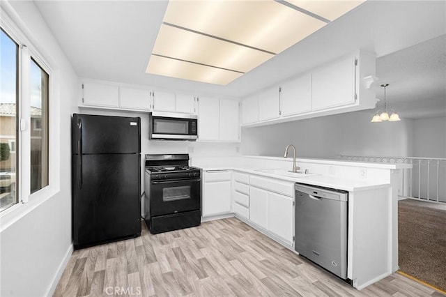 kitchen featuring decorative light fixtures, black appliances, white cabinetry, sink, and kitchen peninsula