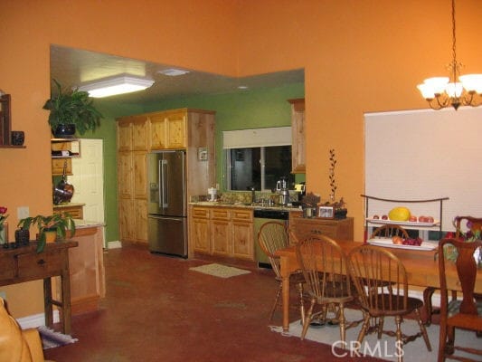 kitchen featuring an inviting chandelier, appliances with stainless steel finishes, and decorative light fixtures