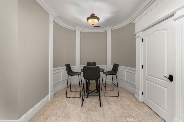 dining area with crown molding, decorative columns, and light carpet