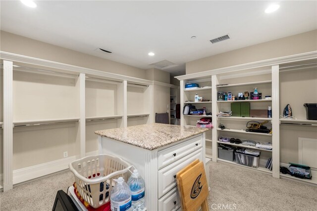 spacious closet featuring light colored carpet