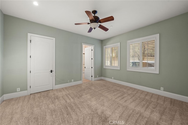 unfurnished bedroom featuring connected bathroom, light colored carpet, and ceiling fan