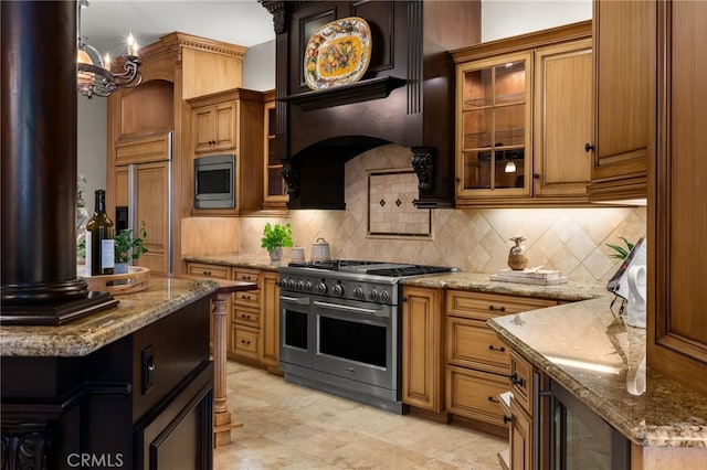 kitchen featuring built in appliances, backsplash, and light stone countertops