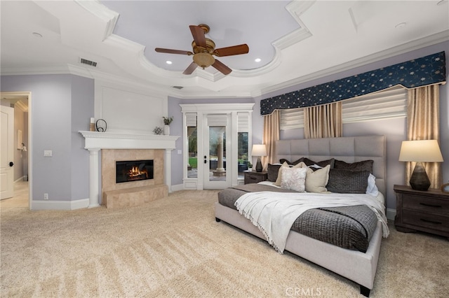 carpeted bedroom with ornamental molding, access to outside, ceiling fan, a high end fireplace, and a raised ceiling