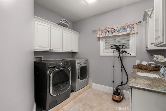 laundry area featuring sink, light tile patterned floors, cabinets, and washing machine and clothes dryer