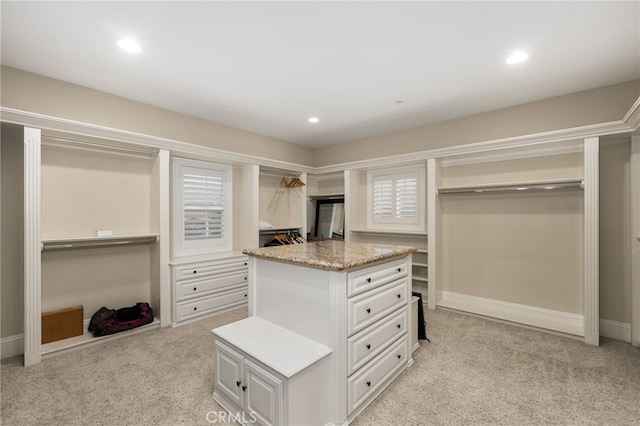 spacious closet featuring light colored carpet