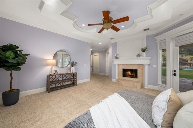 carpeted bedroom with a tray ceiling, ornamental molding, access to exterior, ceiling fan, and a high end fireplace