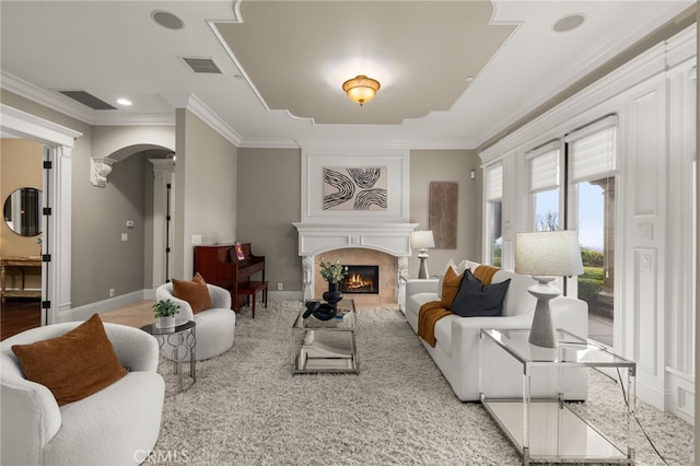 living room featuring crown molding and a large fireplace