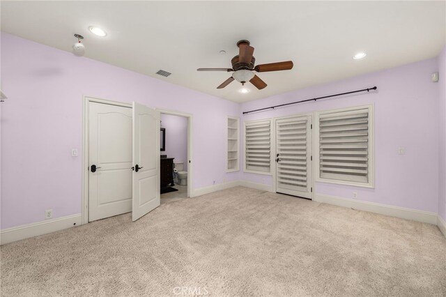unfurnished bedroom featuring connected bathroom, light carpet, and ceiling fan