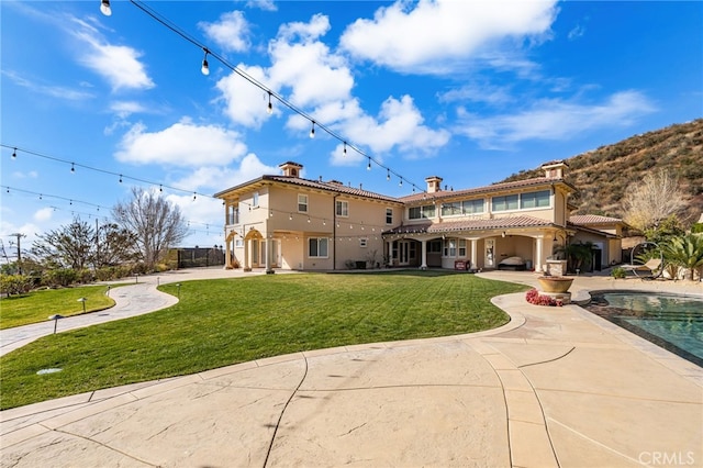 back of property featuring a patio and a lawn