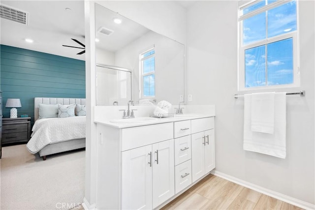 bathroom with walk in shower, ceiling fan, wood-type flooring, and vanity