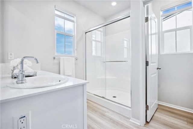 bathroom with hardwood / wood-style flooring, vanity, and an enclosed shower