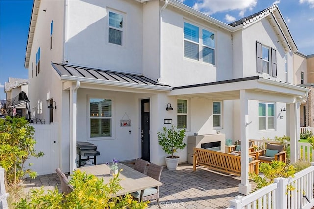 rear view of property featuring an outdoor living space and a patio