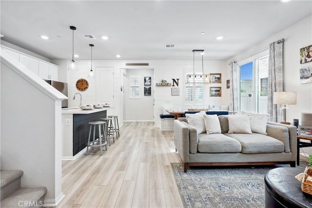 living room with sink and light hardwood / wood-style flooring