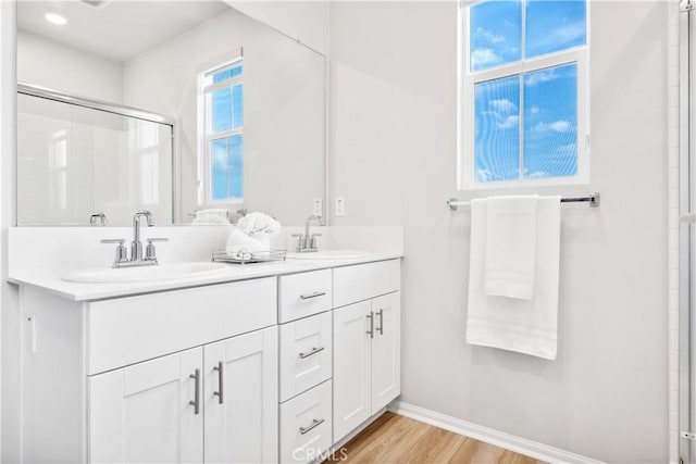 bathroom featuring walk in shower, vanity, and hardwood / wood-style floors