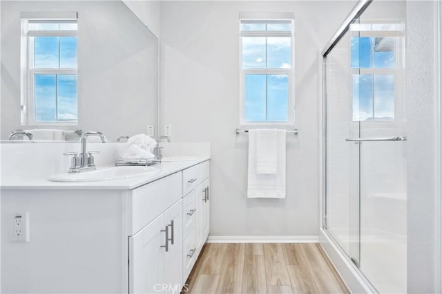 bathroom featuring vanity, hardwood / wood-style floors, and a shower with door