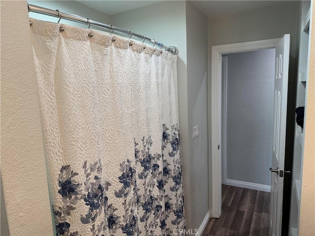 bathroom featuring curtained shower and hardwood / wood-style floors