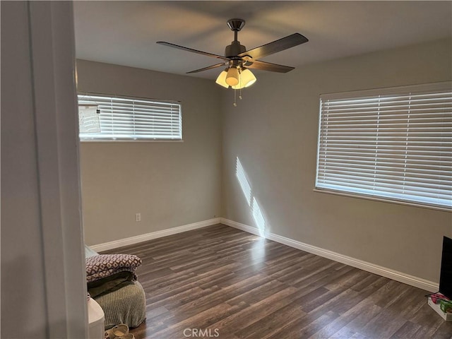 unfurnished room with dark wood-type flooring and ceiling fan