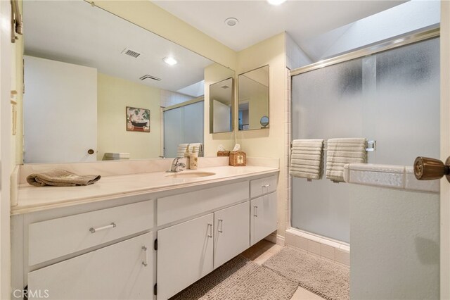 bathroom featuring vanity, an enclosed shower, and tile patterned floors