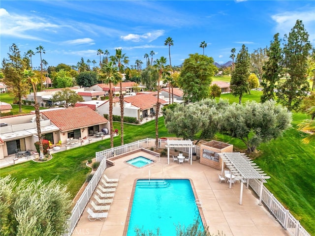 view of pool with a bar, a lawn, a patio area, and a pergola