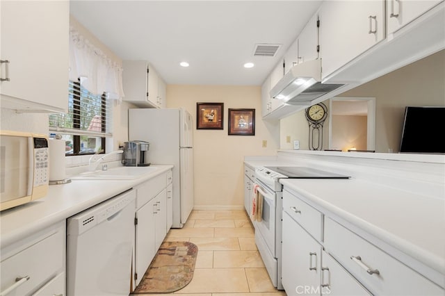 kitchen with white cabinetry, sink, light tile patterned floors, and white appliances