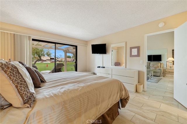 bedroom featuring access to exterior and a textured ceiling