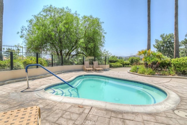 view of pool with a swimming pool, a patio area, and fence