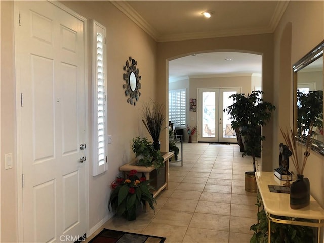 tiled foyer entrance featuring crown molding