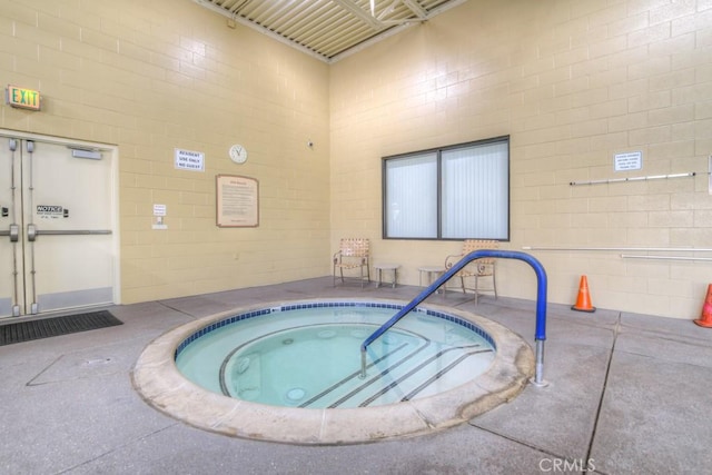 view of swimming pool with an indoor hot tub