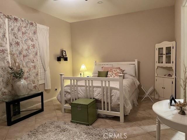 bedroom featuring light tile patterned flooring and baseboards