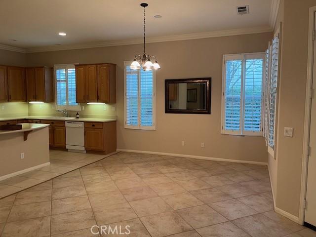 kitchen featuring visible vents, hanging light fixtures, white dishwasher, light countertops, and a notable chandelier