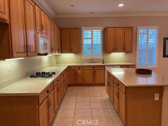 5467 Breckenridge Ave, Banning, CA 92220 - kitchen featuring white appliances, light countertops, light tile patterned flooring, ornamental molding, and brown cabinetry