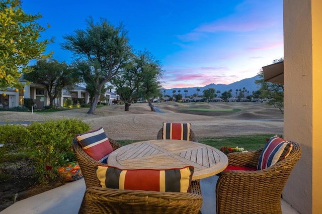 patio terrace at dusk featuring a mountain view