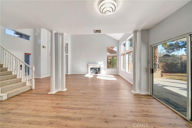 unfurnished living room featuring decorative columns and light hardwood / wood-style floors