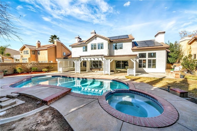 rear view of house featuring a pergola, a pool with hot tub, and a patio