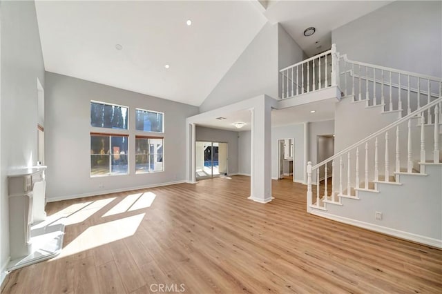 unfurnished living room with light hardwood / wood-style floors and high vaulted ceiling