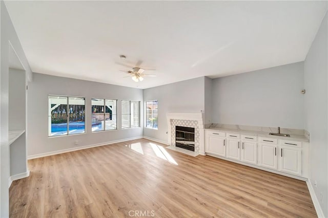 unfurnished living room with ceiling fan and light wood-type flooring