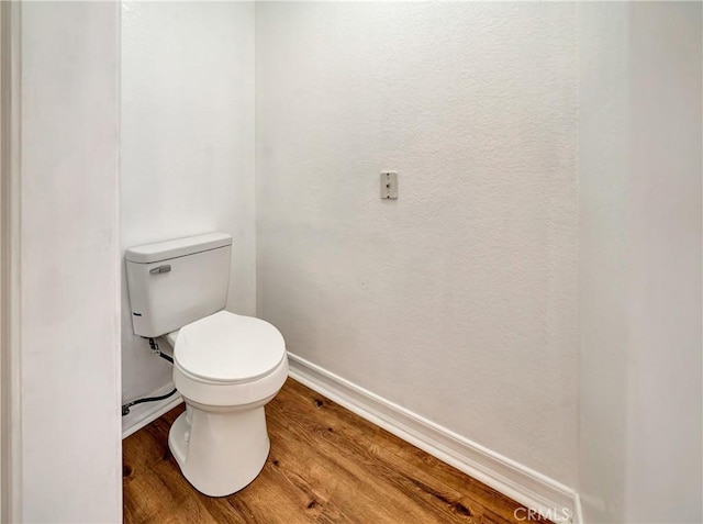 bathroom featuring hardwood / wood-style flooring and toilet