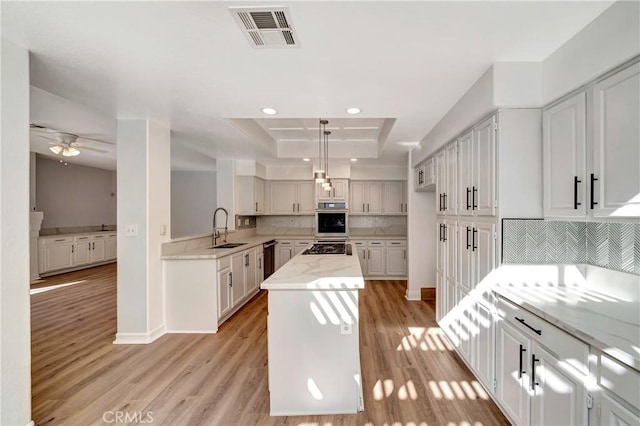 kitchen with sink, backsplash, hanging light fixtures, stainless steel appliances, and a center island