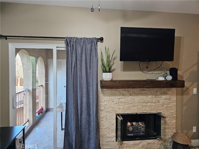 living room with a stone fireplace