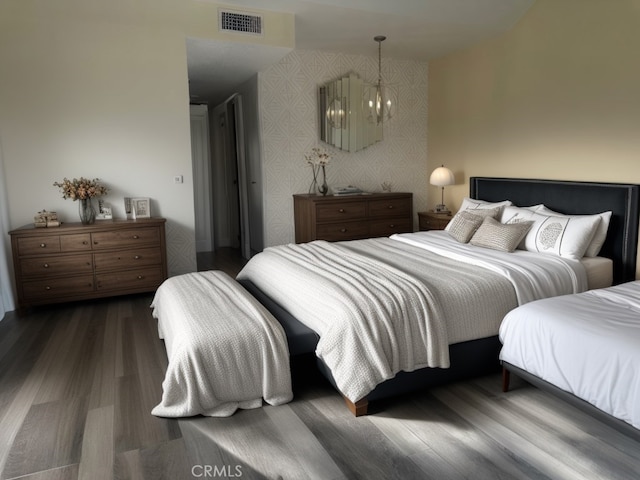 bedroom featuring visible vents, wallpapered walls, dark wood-type flooring, and an inviting chandelier