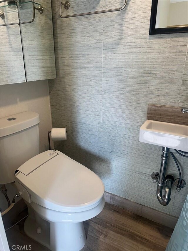 bathroom with hardwood / wood-style flooring and toilet