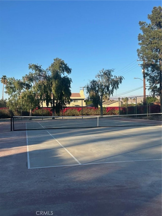 view of tennis court featuring fence