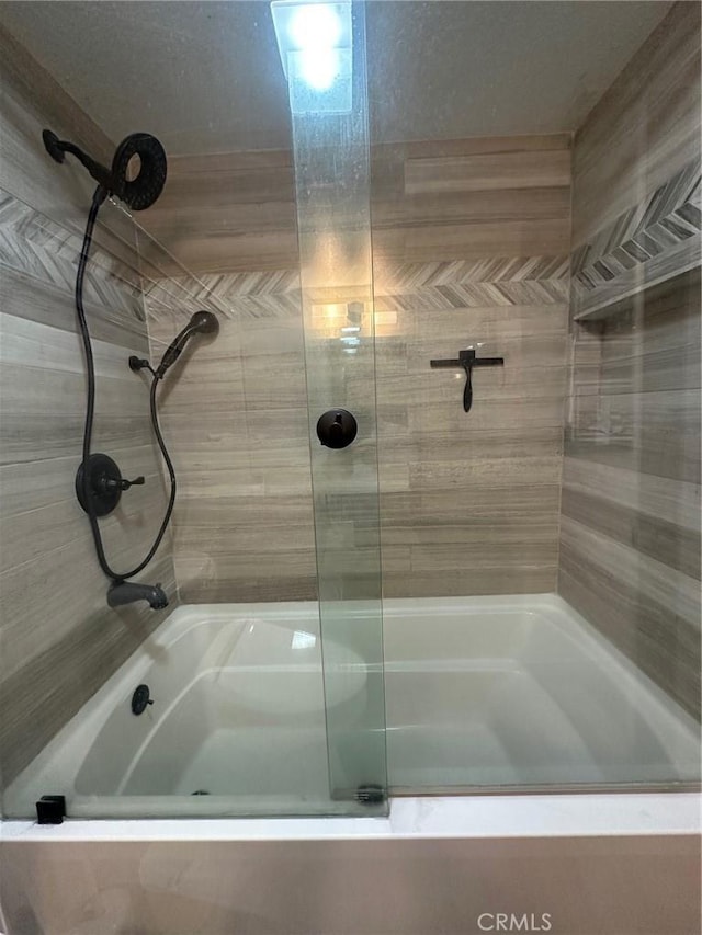 bathroom with shower / bath combination with glass door