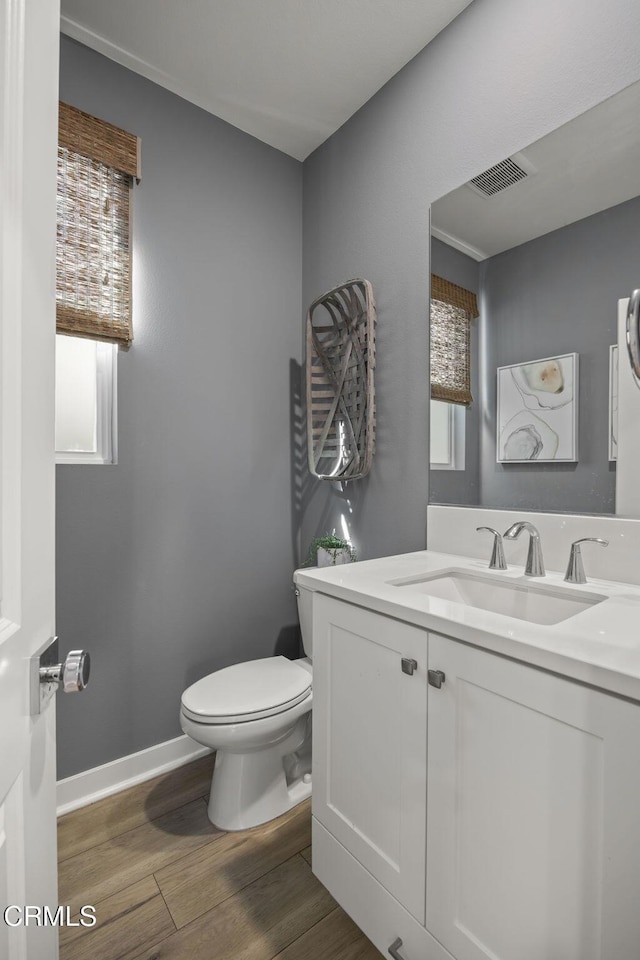 bathroom with vanity, hardwood / wood-style flooring, and toilet