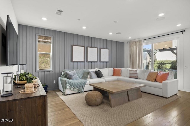 living room with wood walls and light wood-type flooring