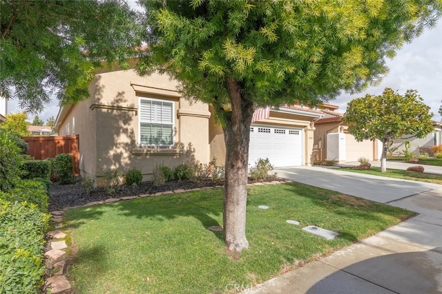 view of front of property featuring stucco siding, concrete driveway, a front lawn, and fence