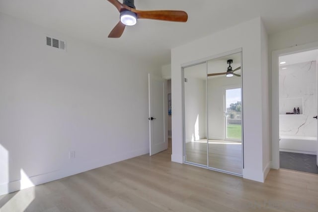 unfurnished bedroom featuring light hardwood / wood-style floors, ceiling fan, and a closet