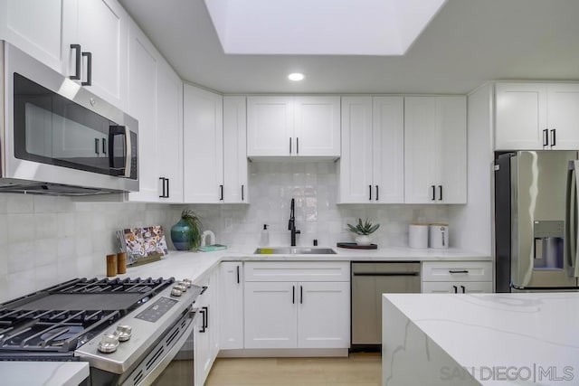 kitchen with sink, white cabinets, and appliances with stainless steel finishes