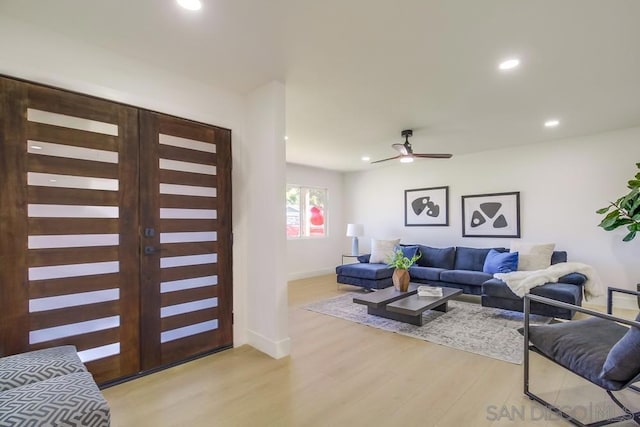 living room featuring ceiling fan, light hardwood / wood-style floors, and french doors