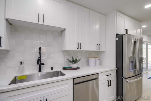 kitchen with white cabinetry, sink, tasteful backsplash, and appliances with stainless steel finishes